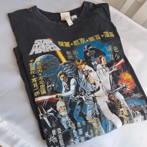 Vintage stil Star Wars t-shirt - Cool stentvättad t-shirt från H&M med färgglatt Star Wars-tryck och asiatiska tecken på framsidan. Oversized passform och klassisk rund hals. Perfekt för dig som älskar retro vibes och film. Materialet är mjuk bomull som känns skönt mot huden.