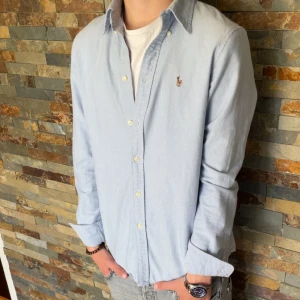 Polo Ralph Lauren skjorta!  - En riktig snygg ljusblå Polo Ralph Lauren skjorta. Denna är verkligen perfekt nu till sommaren, midsommar och den är väldigt stilig. Det är storlek M men passar även på S. Skicket är 10/10, använd några få gånger. Priset jag kommer sälja denna är för 449kr, men kan sänka vid snabb affär. Skriv om ni är intresserade eller har några funderingar. Mvh
