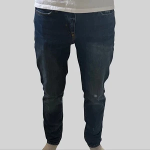 Polo Ralph Lauren jeans blå - Säljer ett par mörkblå jeans från Polo Ralph Lauren med klassisk femficksdesign och snygga kontrastsömmar. Jeansen har rak passform och läderpatch med logga bak i midjan. Perfekta för dig som gillar stilrena och tidlösa jeans.
