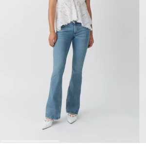 Blå bootcut jeans med låg midja - Snygga blå jeans med bootcut-modell och låg midja. Jeansen har klassisk femficksdesign och är tillverkade i ett mjukt denimtyg som ger en skön passform. Perfekta för dig som gillar en retroinspirerad look.