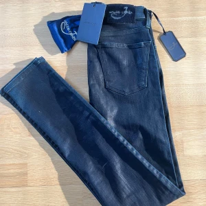 SPRILLANS NYA Jacob Cohen jeans - Snygga mörkblå jeans från Jacob Cohën i modellen Kimberly Slim. Jeansen har klassisk femficksdesign, smal passform och exklusiva detaljer som märkespatch i mocka och broderad insida. Perfekta för dig som gillar stilrena och lyxiga jeans. Prislapp, påse mm finns kvar. Aldrig använda. Ljuset gör så dom ser glansiga ut.