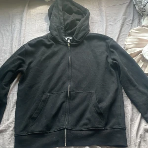 Svart hoodie med dragkedja H&M XXS - Svart hoodie från H&M i storlek XXS med hel dragkedja framtill och två stora fickor. Klassisk modell med huva och mjukt bomullsmaterial. Säljer då den inte används💕