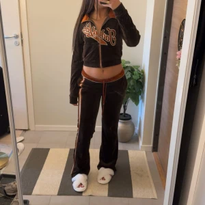 Brunt mjukissett  -  Skönt mjukissett i brun med orangea och vita ränder längs sidorna och dragsko i midjan. Byxorna har en är så sköna och lowwaist(går att ändra utifrån eget önskemål). Settet e perfekta för en chill men ändå snygg look.