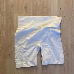 Vita höga cykelshorts i bomull - Vita cykelshorts med hög midja och längre ben. Gjorda i mjuk bomull med stretchig känsla, perfekta för en chill och sportig look. Passar till oversized t-shirt eller hoodie.