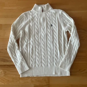 Vit kabelstickad tröja  - Kabelstickad vit tröja. Perfekt för dig som gillar klassisk och stilren look. Priset är ej hugget i sten. 