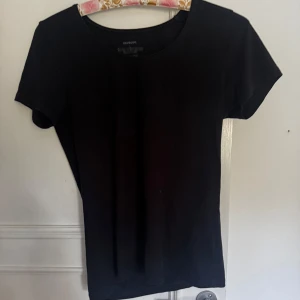 Svart kortärmad topp från Newbody - En basic svart topp från Newbody med rund halsringning och korta ärmar. Tillverkad i mjuk bomull. Kan mötas upp i Norrköping😊