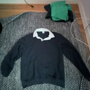 Svart tröja med vit krage från Zara - Snygg svart tröja från Zara med vit klassisk krage som ger en preppy look. Tröjan har långa ärmar och är perfekt för dig som gillar stilrena plagg med en twist. Passar till många olika outfits.