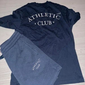 Marinblå t-shirt + tillhörande shorts - Marinblå t-shirt + tillhörande shorts från Jack & Jones med texten 'ORIGINALS' tryckt i vitt på bröstet. Klassisk passform och rund halsringning. Perfekt för en avslappnad stil.