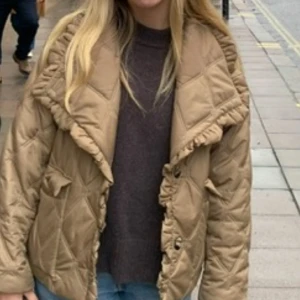 Ganni jacka - Säljer en beige quiltad pufferjacka med stora slag och volangdetaljer längs kragen och framkanten. Jackan har lång ärm och två stora fickor framtill. Den är så så fin och är i väldigt bra skick💗💗💗