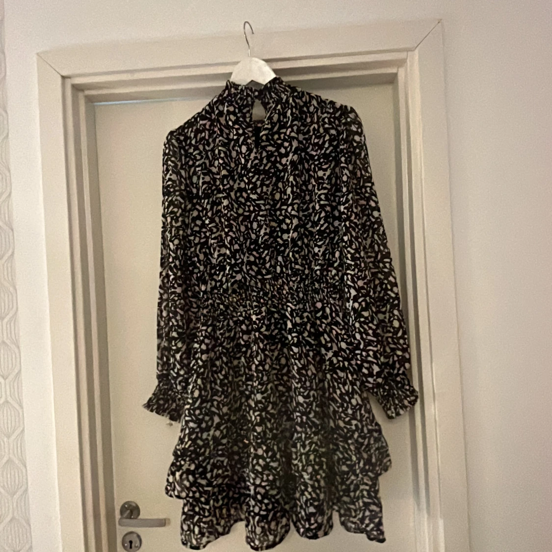 Svart blommig kortklänning med volang - 1