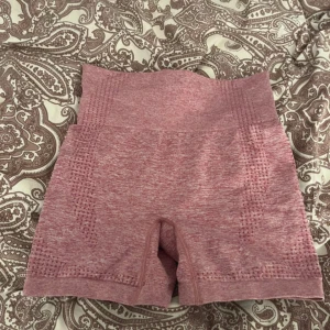 Rosa sömlösa träningstights shorts - Säljer ett par rosa sömlösa shorts i stretchigt material. De har hög midja och är perfekta för träning eller gym. Materialet är en blandning av polyamid, polyester och elastan för maximal komfort och rörelsefrihet.