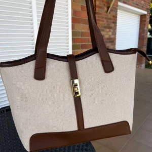 Beige och brun handväska med gulddetalj - Ny, lyxig väska – stilren och praktisk! 😍 Snygg design med gott om plats för allt du behöver 🌸  📏 Mått: Längd: 38 cm Höjd: 25 cm Bredd: 12 cm  🔖 Väska utan märke ✅ Hög kvalitet  🖤 Perfekt för både vardag och jobb!