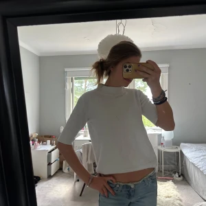 Vit ribbad polotopp - Säljer en vit ribbad polotopp med korta ärmar