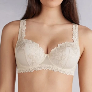 Intimissimi Balconettebehå Sofia Pretty Flowers - Säljer en elegant balconette-bh i ljusbeige med vackra spetsdetaljer och blommigt mönster. Bh:n har breda axelband med spets och dekorativ kant nertill. Perfekt för dig som vill ha en feminin och stilren look.