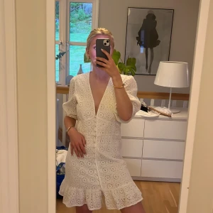 Vit spetsklänning med volang - Säljer en söt vit klänning med v-ringning och volangkant nertill. Klänningen har trekvartsärmar med lätt puff och är gjord i ett broderat spetsmaterial. Perfekt för sommarens tillfällen! Stl 38 men passas S