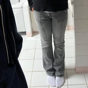 Grå bootcut jeans med kontrastsömmar - Säljer ett par grå jeans med bootcut-modell och tydliga kontrastsömmar. Byxorna har klassiska fickor fram och bak samt normal passform. Perfekta för dig som gillar en stilren och enkel look.Ny pris cirka 400kr🥰🥰