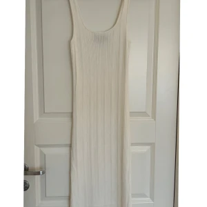 Stickad klänning - Säljer en ribbad midiklänning i ärmlös design. Klänningen är tillverkad i ett mjukt material. Perfekt för sommarens alla tillfällen! Oanvänd. 