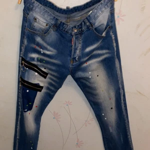 Blå Dsquared2 jeans med dragkedjedetaljer - Blåa dsq2 jeans, använt 3 gånger och har ingen användning av dom för att det är sommar snart. Priset är inte spikat och skriv gärna om du har några frågor eller om du vill ha fler bilder. OBS storleken som står på byxorna stämmer inte dom är mindre än vad det står.