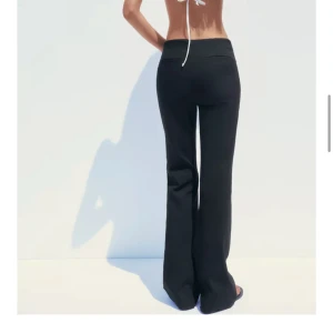 Svarta kostymbyxor med bootcut - Snygga svarta kostymbyxor med bootcut och hög midja. Byxorna har klassisk passform, stängs med dragkedja och knapp framtill och har fickor bak. Perfekta för en stilren look.