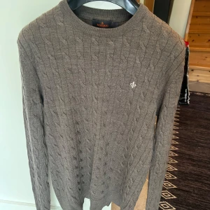Brun kabelstickad tröja från Morris - Säljer en brun kabelstickad tröja från Morris i 100% merinoull. lång ärm och en liten broderad logga på bröstet. Strl M men sitter som en S