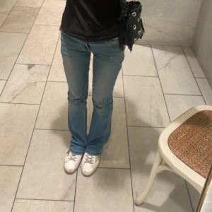 Ljusblå bootcut jeans - Säljer ett par ljusblå jeans med bootcut passform. Klassisk femficksmodell och normalhög midja. Perfekta till sneakers eller boots för en avslappnad stil.