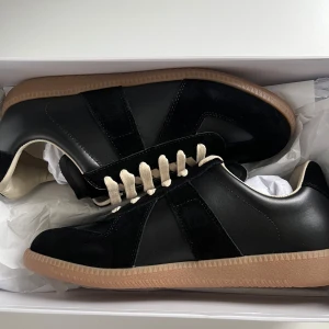 Svarta sneakers från Maison Margiela - Säljer ett par feta gats från maison margiela. Original box tillkommer. Obs : ni vet varför de e så billiga Ni kan gärna höra av er om ni har några funderingar.
