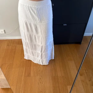Vit långkjol med spetsdetaljer - Säljer en vit långkjol med spetsdetaljer. Super fin till sommaren och passar till allt!💕Jag är 173 cm!