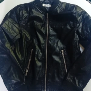 Svart skinnjacka från H&M - Säljer en svart skinnjacka från H&M med dragkedja framtill och två snedställda fickor med dragkedjor. Säljer den för 100 kr för jag haringen använing för den.