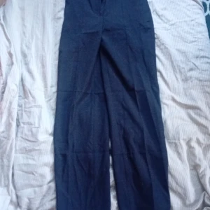 Svarta kostymbyxor från H&M - Snygga svarta kostymbyxor från H&M med hög midja och raka ben. Perfekta för en stilren look och passar till många olika outfits. Har använte den två gånger 