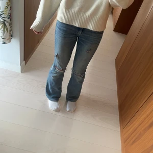 Blå slitna jeans med hål - Säljer ett par blå jeans med slitningar och hål på knäna. 