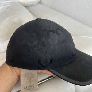 Svart Gucci GG jumbo keps - Säljer en äkta svart gg jumbo Gucci keps i storlek M (58 cm) Kepsen är i ganska bra skick och har justerbart spänne baktill. 