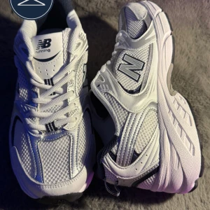 New Balance 530 vita sneakers strl 43 - Säljer ett par New Balance 530 sneakers i vitt med silvriga och svarta detaljer. Skorna har meshpaneler för extra andningsförmåga, klassisk snörning och en chunky sula med svart yttersula. Perfekta för dig som gillar retrovibbar och sportig stil. Priset är ej hugget i stenen ännu✅ Skriv gärna vid minsta lilla funderingar 
