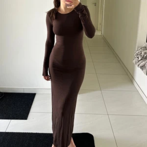 Långärmad klänning Gina Tricot -  långärmad brun långklänning grån Gina Tricot. Klänningen har en figurnära passform och är tillverkad i ett mjukt, stretchigt material som sitter snyggt på kroppen. Endast testad, storlek xs 💗