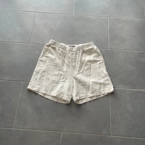 Beige linneshorts med resårmidja - Snygga och luftiga beige shorts i linne med avslappnad passform och elastisk midja. Perfekta för varma dagar när du vill ha något bekvämt och stilrent. Klassisk modell utan onödiga detaljer.