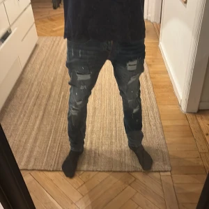 Blå jeans från Dsquared2 - Snygga blå jeans från Dsquared2 med slitna detaljer och en cool, distressed look. De har en klassisk femficksdesign och knappgylf. Perfekta för en avslappnad stil med en touch av edge.