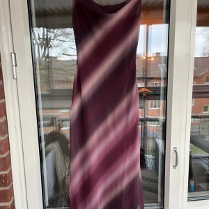 ✨ NY! Pretty Lavish “Kesha” klänning – Wine Ombre (strl UK 6 / EU 34) ✨ - Klänning från Pretty Lavish – ny med lappar kvar! Modell: Kesha Asymmetric Cowl Maxi Dress och är i färgen Wine Ombre – en elegant vinröd ton med ljusa diagonala skiftningar. 🖤 Premium chiffong (fully lined) 🖤 Asymmetrisk draperad halsringning 🖤 Lätt figursydd passform 🖤 Dold dragkedja i sidan 🖤 Material: 100% polyester 🖤 Storlek: UK 6 (motsvararr ca 32/34 EU)  Nypris: ca 1200 kr, *slutsåld på hemsidan  Tyvärr är det en tråd som gått baksida av klänning, ca 10 cm upp från slutlängd (bild 5)