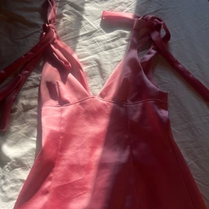 Rosa linnetopp med knyt från Zara - Supersöt rosa linnetopp från Zara med v-ringning och knytbara axelband. Toppen har en lätt glansig finish och figurnära passform som ger en feminin siluett. Perfekt att styla med jeans eller kjol för en trendig look. HELT SLUTSÅLD PÅ ZARA!!!!!! Kommer ej tillbaka!
