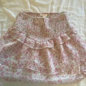 rosa blommig kjol från Gina Young 💞 - snygg blommig kjol från Gina Young, fina vita o gröna blommor, kort o snygg. Perfekt för en varm strand dag 🫰🏼🫰🏼