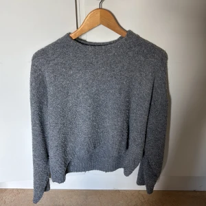 Grå stickad tröja från H&M - Mysig grå stickad tröja från H&M i storlek S. Tröjan har en rak, lite loose passform med rund halsringning och långa ärmar. Tröjan är knappt använd och i bra skick.