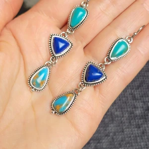  Helt nya Boho örhängen med blå stenar -  Helt nya Unika örhängen i silverfärgad metall med tre droppformade och triangulära stenar i blått och turkost, med inslag av brunt. Detaljerad kantdekor och mönstrad baksida ger en cool boho-vibe. Ca 5 cm långa, perfekta för att sticka ut.