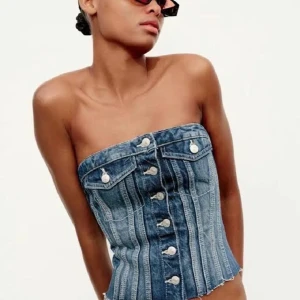 Jeans tubtopp med knappar - Säljer en supersnygg jeans korsett med knappar framtill och rå, fransig nederkant. Toppen är i mycket bra skick och storlek xs. Skriv till mig innan du köper❤️