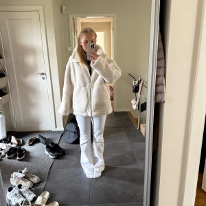 Beige teddyjacka HM - Mysig beige teddyjacka med hög krage och stora fickor framtill. Perfekt för kalla dagar när du vill vara både varm och snygg. Fint skick förutom lite missfärgad av jeans på insidan längst ner (se bild) inget man märker på utsidan.