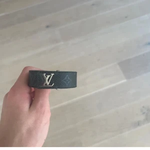 Svart Louis Vuitton armband  - Svart armband Louis vuitton i storlek 21cm. Det finns tre olika  hål så du kan justera storleken . Nypris 3200 mitt pris 1299. Kvitto finns att visas , säljs billigt pågrund av att det inte finns någon låda och att jag bli av med den! .