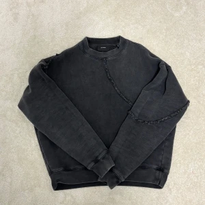 Svart sweatshirt från Axel Arigato - Cool svart sweatshirt från Axel Arigato med unika råa sömmar och broderad logga baktill. Tröjan har en loose fit och är tillverkad i mjuk bomull. Perfekt för dig som gillar streetwear och vill sticka ut med detaljer. I have receipt! 