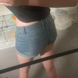 Blå jeansshorts från Esmara - Snygga blå jeansshorts från Esmara med klassisk femficksdesign och uppvikta benslut. Shortsen har gylf med guldfärgad knapp och bälteshällor. Perfekta för varma dagar och enkla att matcha med allt. Går att vika upp om man vill ha dom korta men går oxå bra att vika ner om man vill ha längre