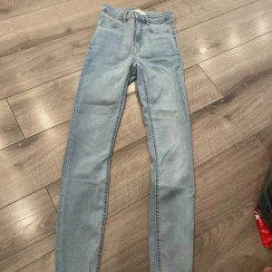 Ljusblå skinny jeans - Aldrig använd. Säljer ett par ljusblå skinny jeans med klassisk femficksdesign och dragkedjegylf. Jeansen har en smal passform och är perfekta för dig som gillar en tight look. Materialet är mjukt och stretchigt för extra komfort.