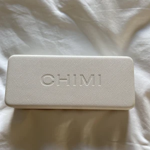 Transparenta CHIMI solglasögon - Snygga solglasögon från CHIMI med transparent, fyrkantig båge och mörka linser. Kommer med originalfodral och putsduk. Perfekt accessoar för att lyfta din stil med en modern och clean look.
