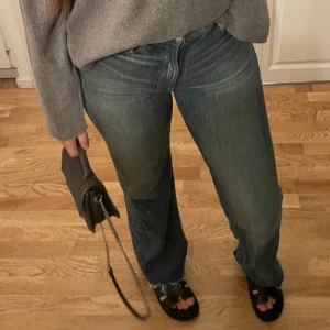 Blå raka jeans från Zara, strl 38 - Säljer ett par blå jeans från Zara i rak modell med hög midja. Jeansen har snygg tvätt, råa kanter nertill och klassisk femficksdesign. Perfekta till sneakers eller boots och passar dig som gillar en avslappnad men trendig look.