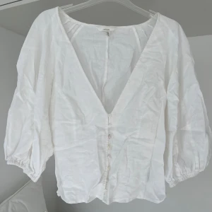 Linnetopp med v-ringning - Söt linnetopp med knappar, v-ringning och trekvartärmar. Aldrig använd. 