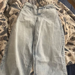 Ljusblåa wide leg jeans - Säljer ett par ljusblåa jeans med wide leg passform. Jeansen har klassisk femficksdesign, gylf med dragkedja och knapp samt raka ben. Perfekta för en avslappnad och trendig stil. Säljer dessa helt nya jeans från hm eftersom de var för små.